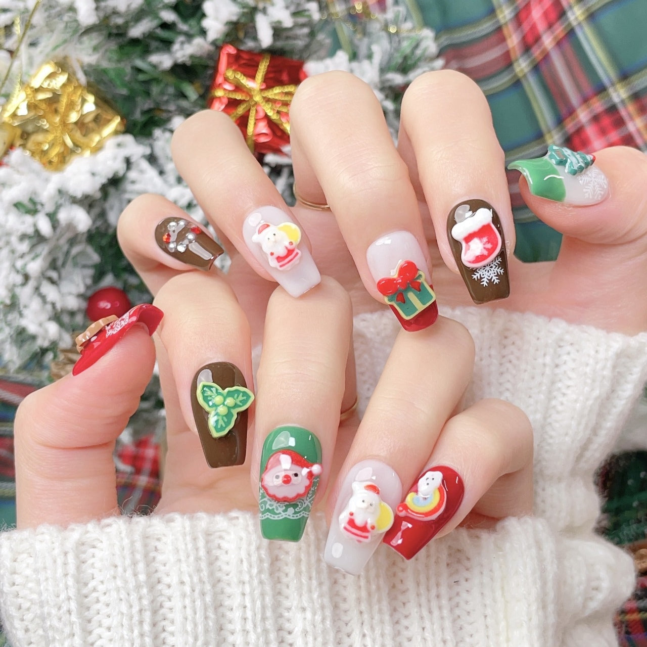 Festive Christmas-themed nails featuring detailed 3D designs, including Santa Claus, bows, snowflakes, and holiday ornaments, in red, white, brown and green colors, creating a joyful and celebratory look.